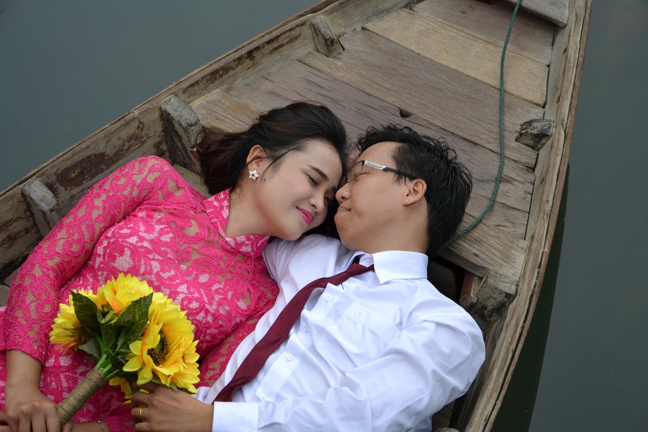 Man and Woman Laying on Brown Wooden Canoe